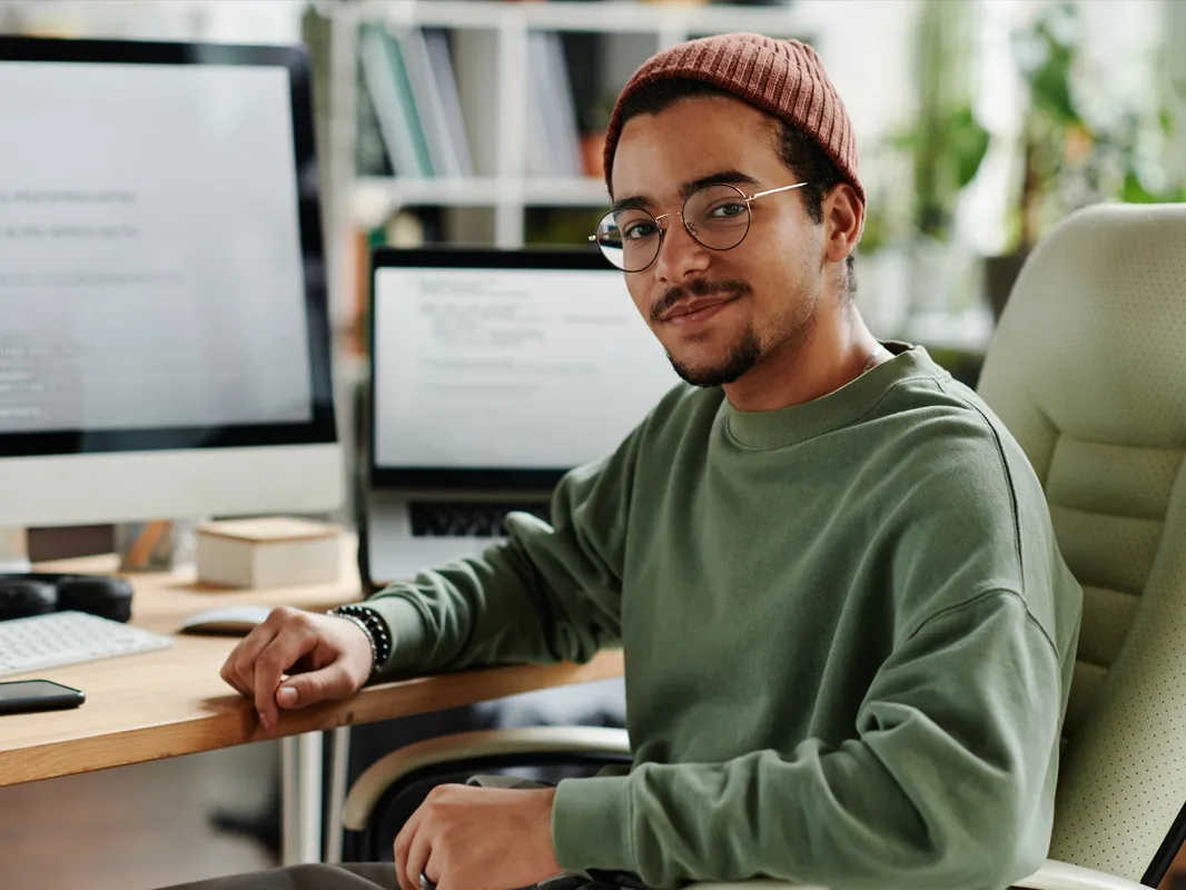 young man poses in front of computer